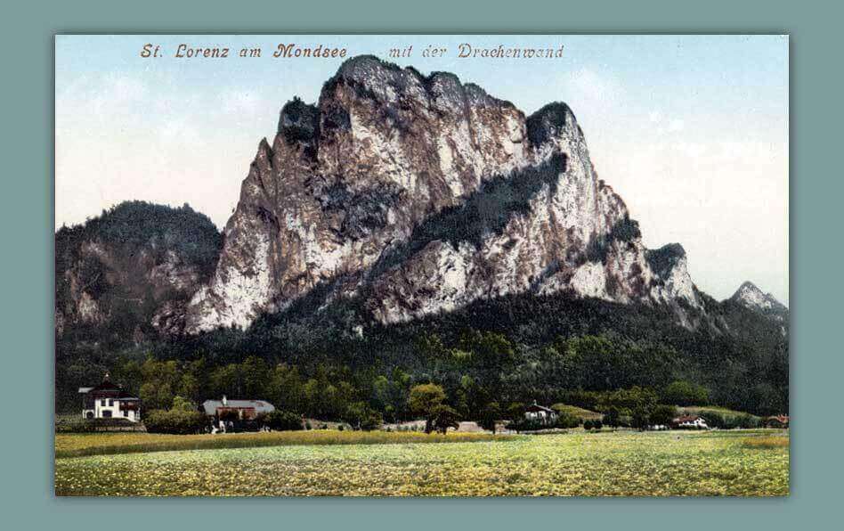 St. Lorenz am Mondsee mit der beeindruckenden Drachenwand im Hintergrund, malerische Alpenlandschaft.