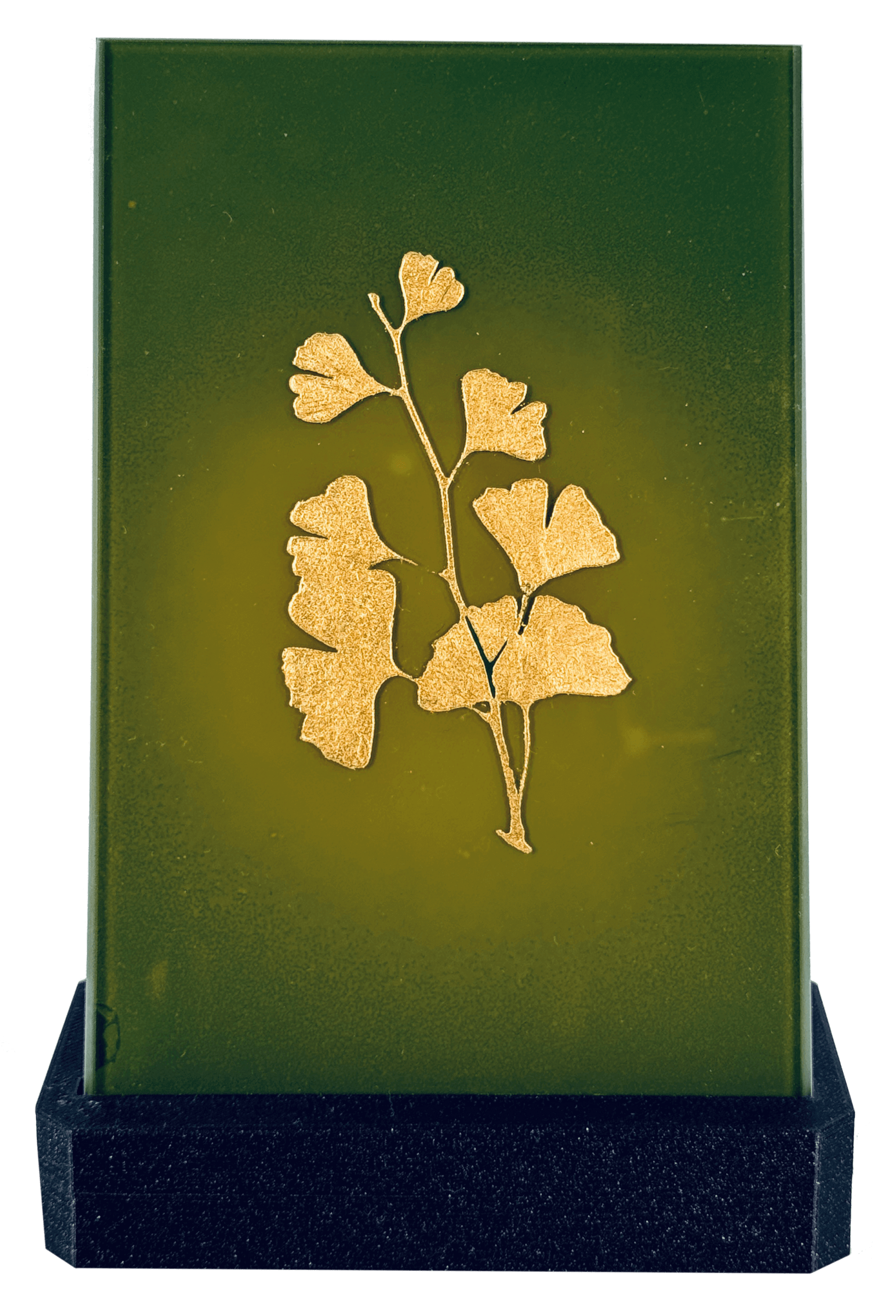 Goldenes Gingko-Blatt-Motiv auf grünem Hintergrund, dekorativ gestaltet und auf schwarzem Sockel präsentiert.