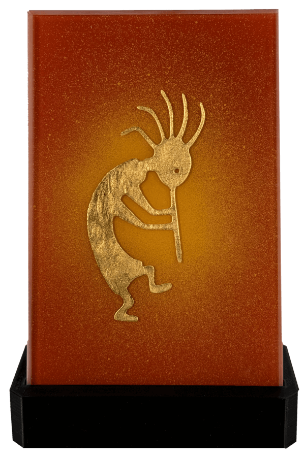 Goldene Kokopelli-Figur auf orangefarbenem Hintergrund, Darstellung einer mythischen Flötenspieler-Symbolik.