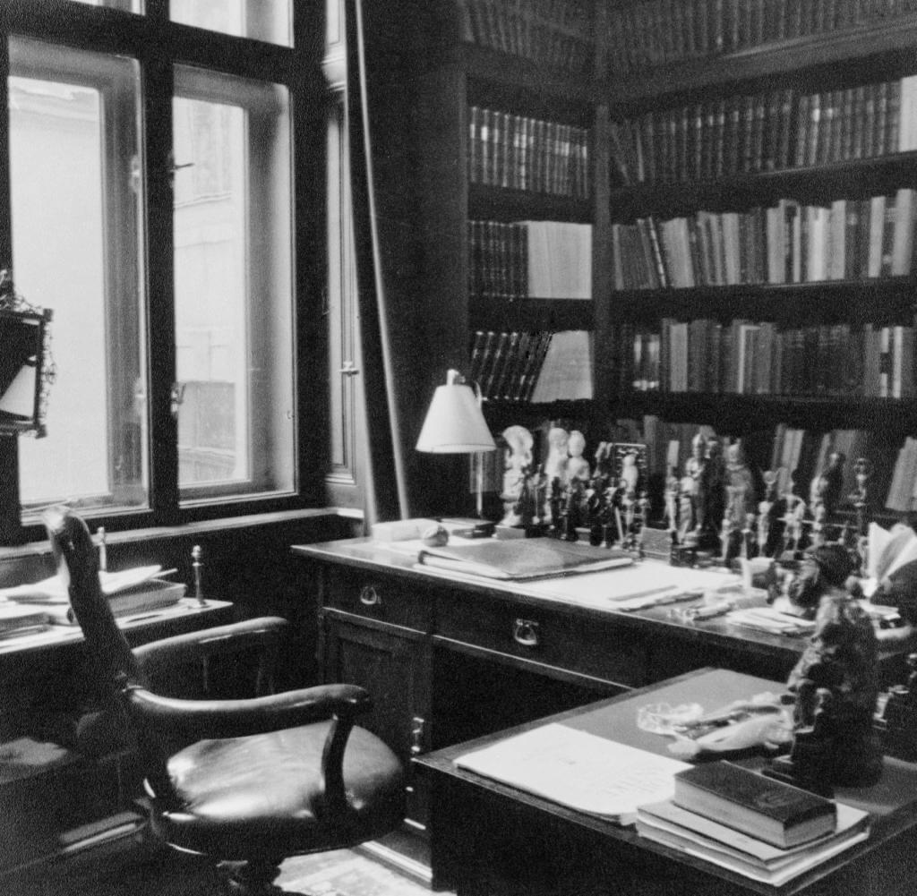 Historisches Arbeitszimmer mit Schreibtisch, Beleuchtung, Bücherregalen und dekorativen Gegenständen für eine klassische Atmosphäre.